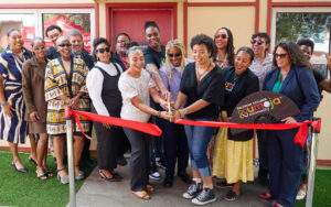 Palomar College employees cutting the grant opening ribbon for the Umoja Village at the San Marcos campus.