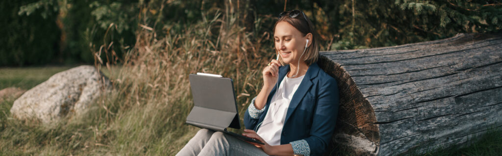 Student sitting outdoors and learning online. 