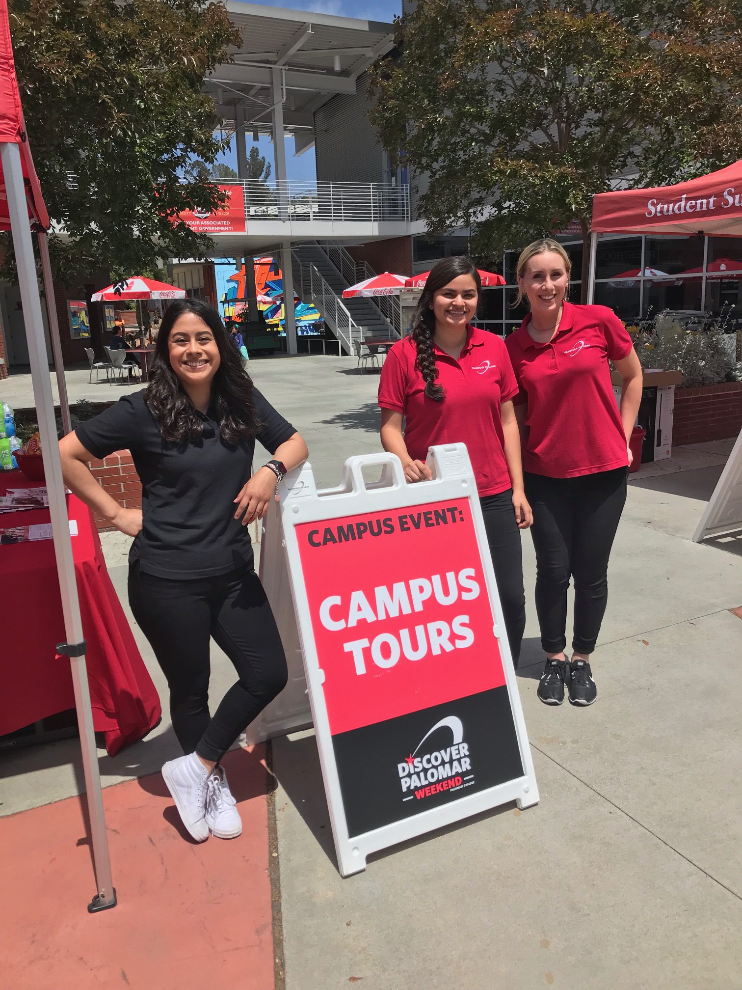 Outreach Services staff at Campus Tours sign