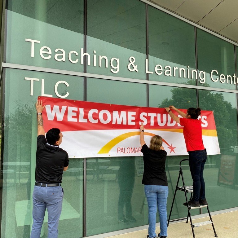 Outreach and Promise staff putting up a welcome students sign