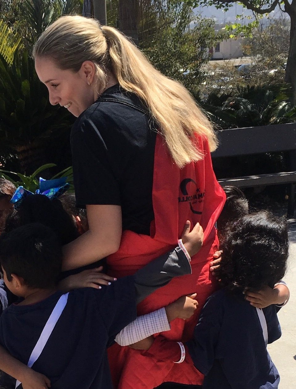 Tour guide with kindergarten tour Palomar Ambassador receiving hugs from prospective students