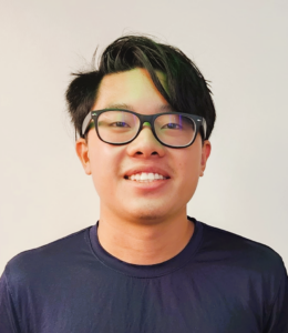 Tan Is smiling while in a navy blue shirt.