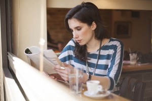 Photo of Woman Reading a Journal at a Cafe