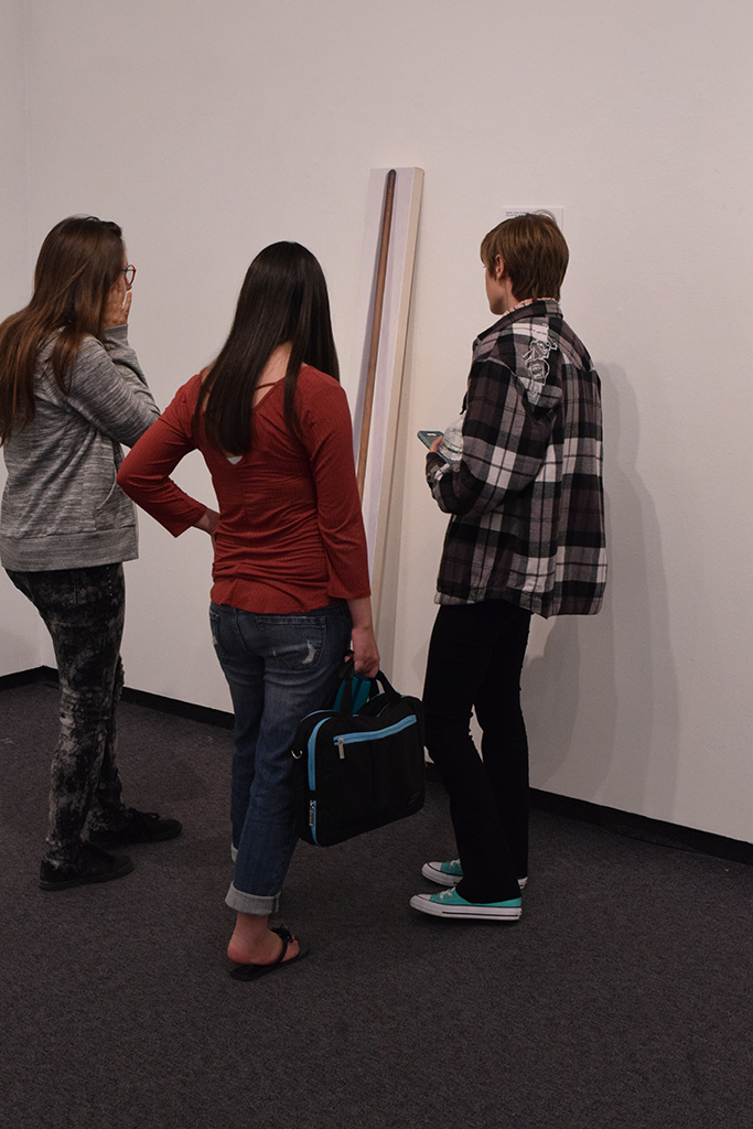 Theresa Campen,Natalie Bauns and Phoenix Rose sand in front and talk about kristin Calabrese painting of a broom she used to clean her side of the warehouse during The Maker's Eye opening receptions.Oct.5th Boehm Gallery Palomar college.Victoria Bradley/The Telescope