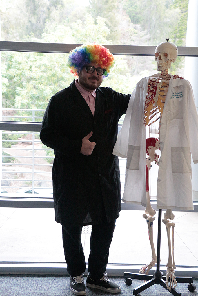 Jason Garrido, a tutor for the STEM Lab, poses with the lab skeleton on April 13. Christopher Jones/The Telescope