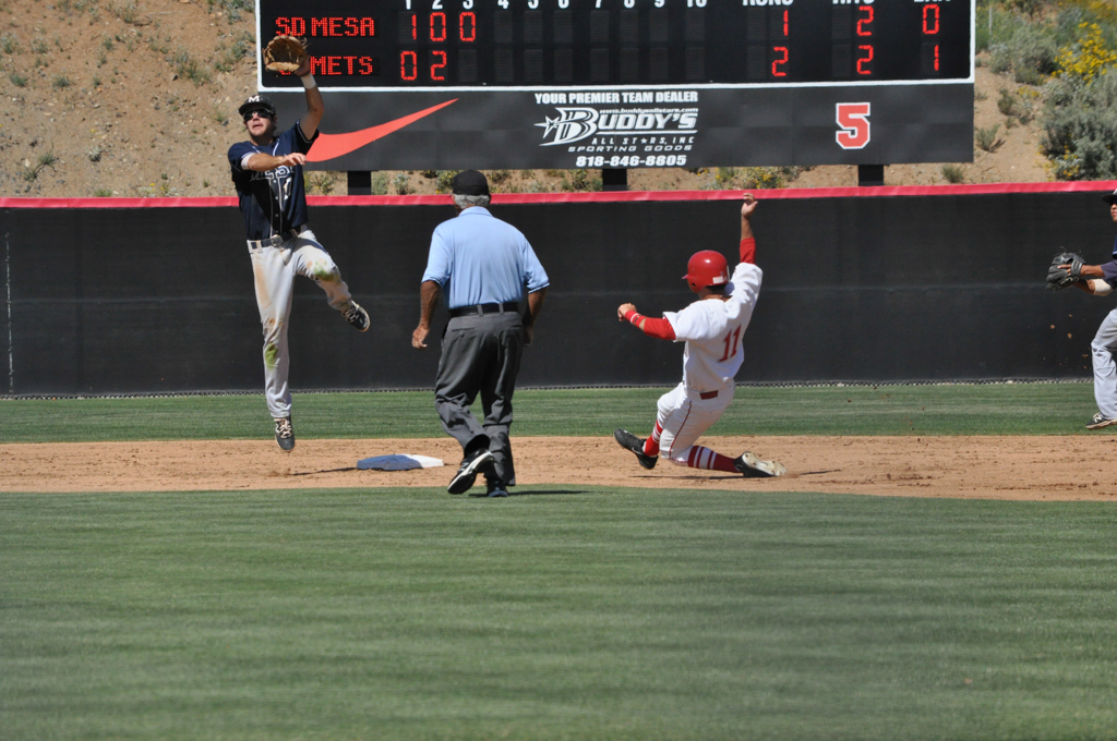 Palomar Sam Casinelli (11) slides into second base and ends up advancing to third base as well following a Mesa wild throw. Casinelli had a solid outing for the Comets, getting on base 2 out of his 3 at bats March 25 vs. San Diego Mesa. Aaron Fortin/ The Telescope