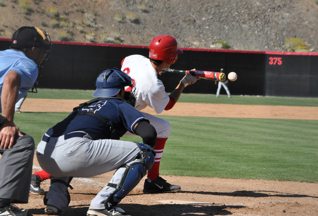 Palomar second baseman Mitch Gallagher {20) lays a bunt down the first base line and is able to make it on base. He would later advance through all the bases and score a run for the Comets who went on to win 9-3 March 25 vs. San Diego Mesa. Aaron Fortin/ The Telescope