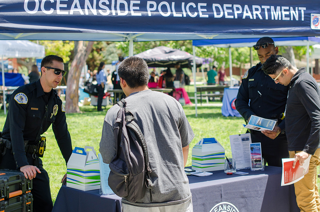 Two officers from the Oceanside Police Department hand out information packets on careers in law enforcement to any Palomar students who stoped by amd inquired. Tracy Grassel/The Telescope