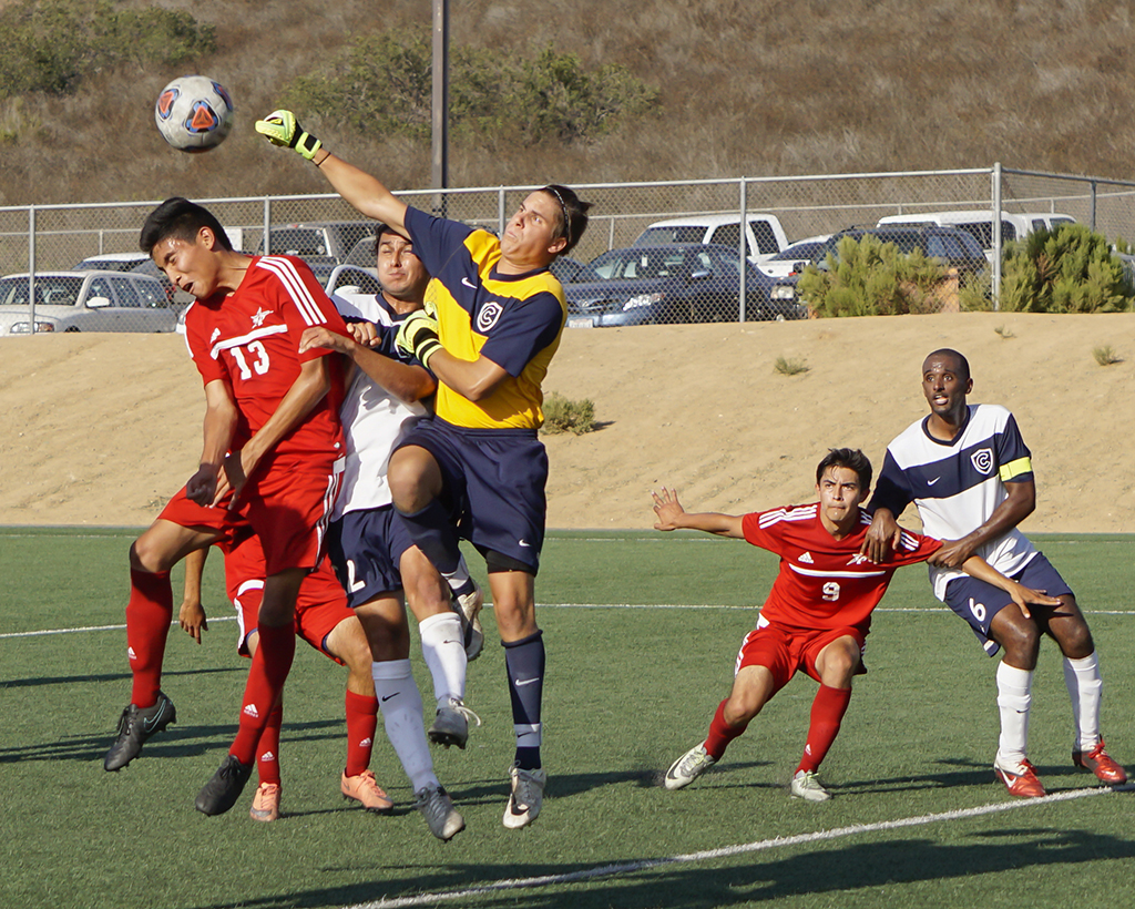 Palomar’s Derek Ayala (13) has the ball punched away by Cypress College goalie Braydon Welch (far right) late in the second half. The Comets hosted the Chargers at Minkoff Field Sept. 6 and lost 2-1. The Comets record now stands at (0-2-2 Overall, 0-0-0 PCAC). Philip Farry / The Telescope