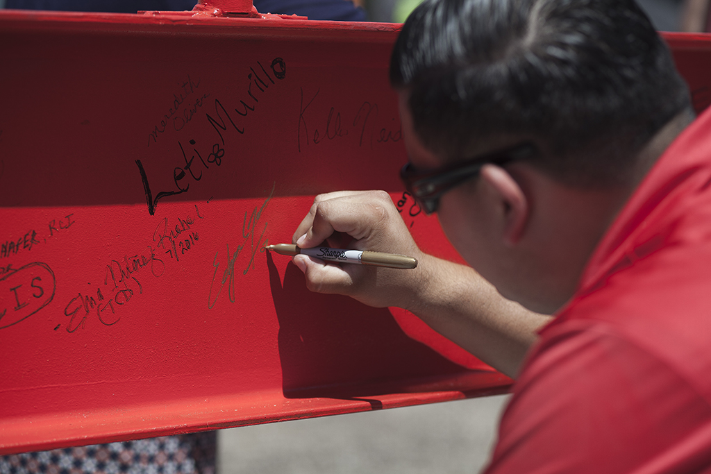 Palomar College Student Ambasador Edgar Garcia signs the Library/Learning Resource Center's top beam prior to it being hoisted onto the structure on July 28 at the San Marcos campus. Stephen Davis/The Telescope