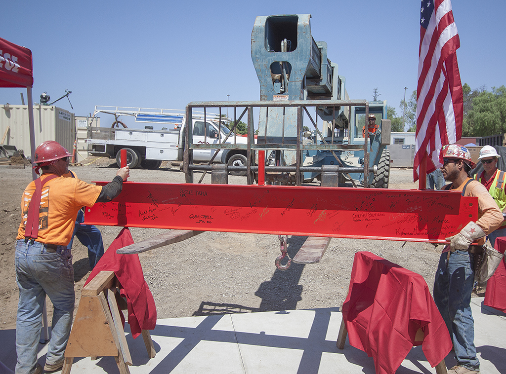 Members of the construction team use a forklift to move the Library/Learning Resource Center top beam into place during the Topping Out ceremony on July 28 at the Palomar College San Marcos campus. After being signed by attendees at the ceremony, the beam was hoisted up and bolted into place on the structure. Stephen Davis/The Telescope