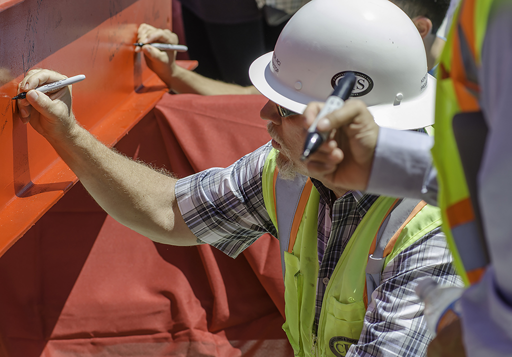 CIS crew member Kent Scarfer signs the final beam before it was hoisted and bolted into the new Library/Learning Resource Center during the Topping Out Ceremony held on July 28 at the San Marcos campus. Tracy Grassel/The Telescope