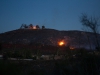 A house at the top of the hill and hillside brush burn at the end of the day during the Liberty Fire, Dec. 8. Savhanna Vargas/ The Telescope
