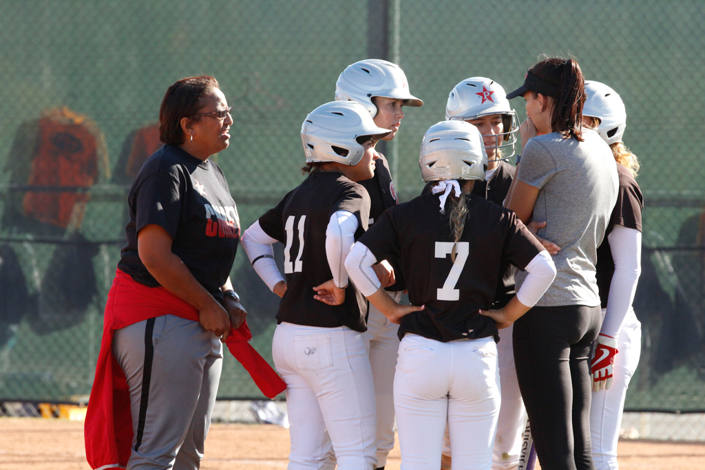 Palomar softball head coach, Lacey Craft, talks to the base runners and batter during a timeout in the bottom of the 7th inning on Feb. 16. Amanda Raines/The Telescope