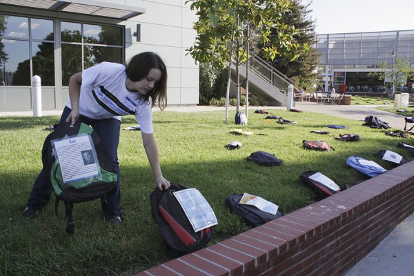 Sept. 12, 2013 | Shayla Fox sets backpacks with notes of the loves ones who lost a loved one to a suicide along side the brick wall at Palomar College. (Guillermo Escamilla/The Telescope)