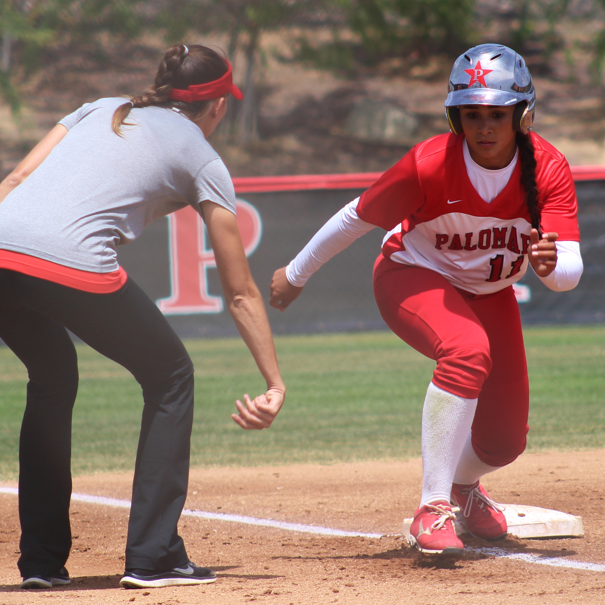 Palomar head softball coach Lacey Craft signals to outfielder Keilani ‘KK’ Fronda to tag up from third base on Carlie Daniel’s sacrifice fly in the 1st inning against Imperial Valley College on April 23 at Palomar’s softball field. Fronda hit for the cycle with 2 homeruns, a triple, double, single, and 8 RBI’s in the Comet’s 25-0 win over the Arabs. The win gave the Comet’s a perfect 18-0 conference record for the first time since 2005. Scott Colson/The Telescope