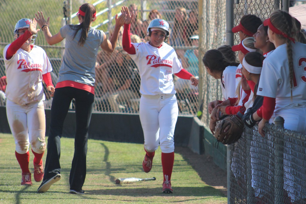 Palomar’s head softball coach Lacey Craft congratulates shortstop Kali Pugh (left) and outfielder Keilani ‘KK’ Fronda (right) after scoring on designated hitter Carlie Daniel’s RBI double against Riverside City College on April 15 at Palomar’s softball field. Fronda and Pugh both went 3-4 in the Comets’ 9-4 win over the Tigers in a rematch of the 2013 state title game when Palomar brought home a championship with a 7-2 win. Scott Colson/The Telescope