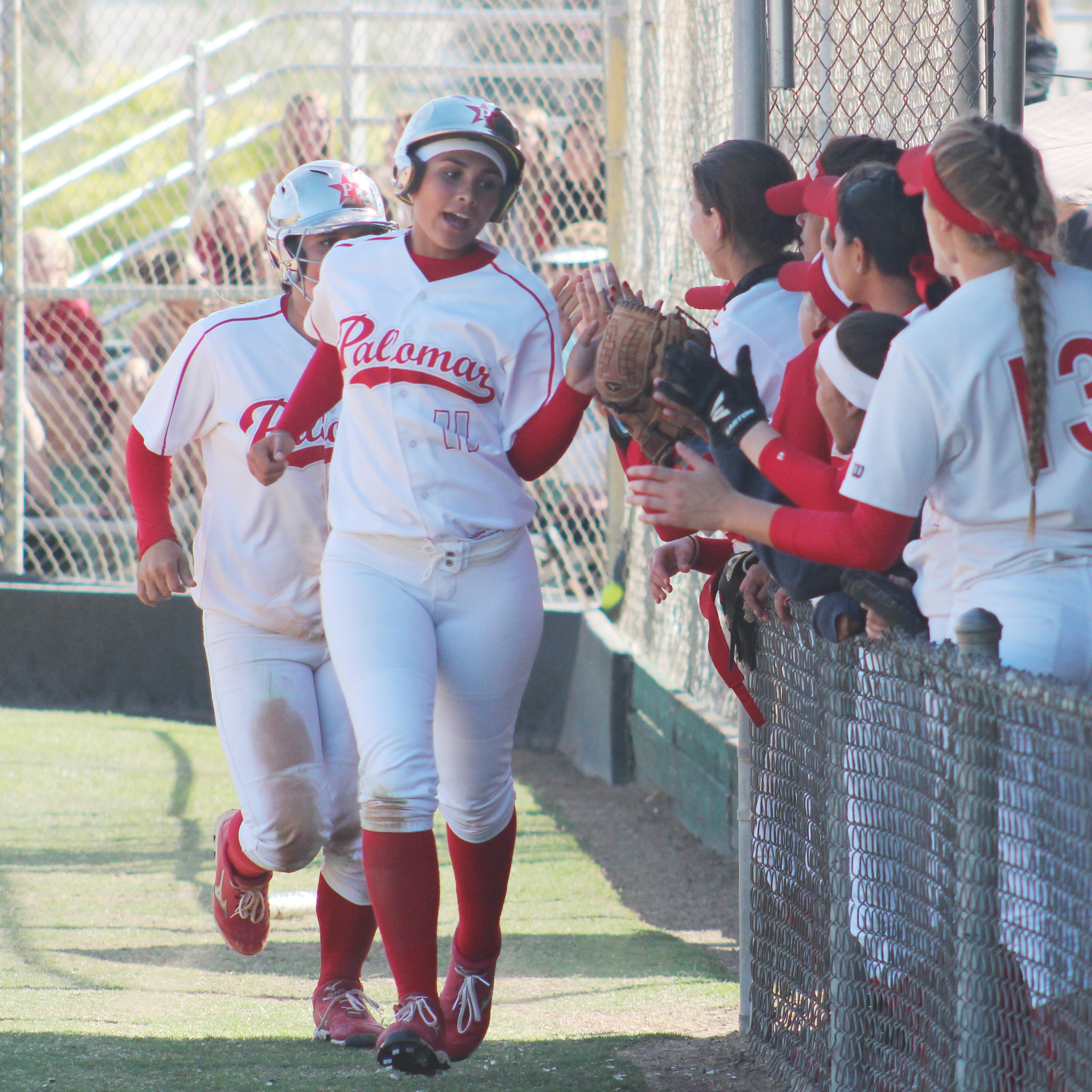 Palomar’s softball team congratulates outfielder Keilani ‘KK’ Fronda and shortstop Kali Pugh after scoring on designated hitter Carlie Daniel’s RBI double against Riverside City College on April 15 at Palomar’s softball field. Fronda and Pugh both went 3-4 in the Comets’ 9-4 win over the Tigers in a rematch of the 2013 state title game when Palomar brought home a championship with a 7-2 win. (Scott Colson/The Telescope)