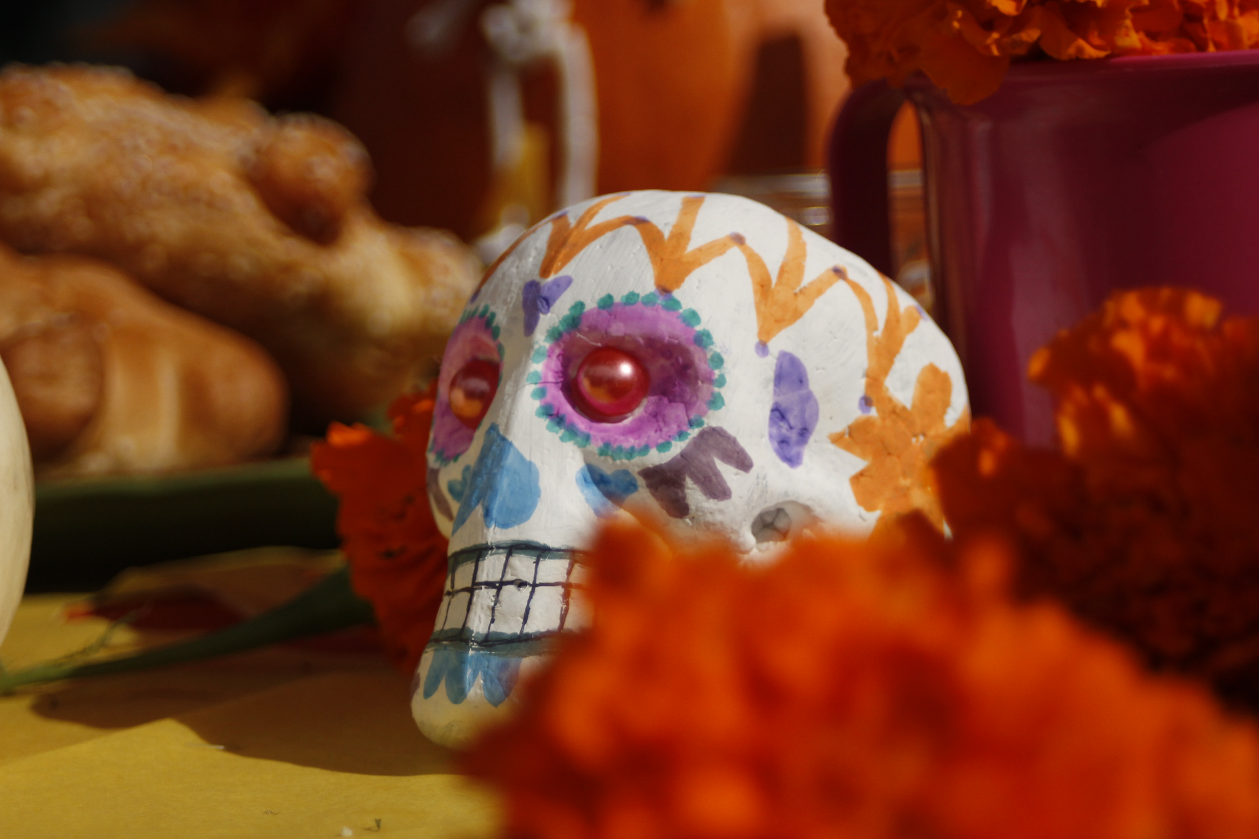 PUENTES decorated their club booth in a Dias de las Muertos theme with sugar skulls, ofertas, and marigolds at the Halloween Escape event Oct. 30, 2014. (Angela Marie Samora/The Telescope)