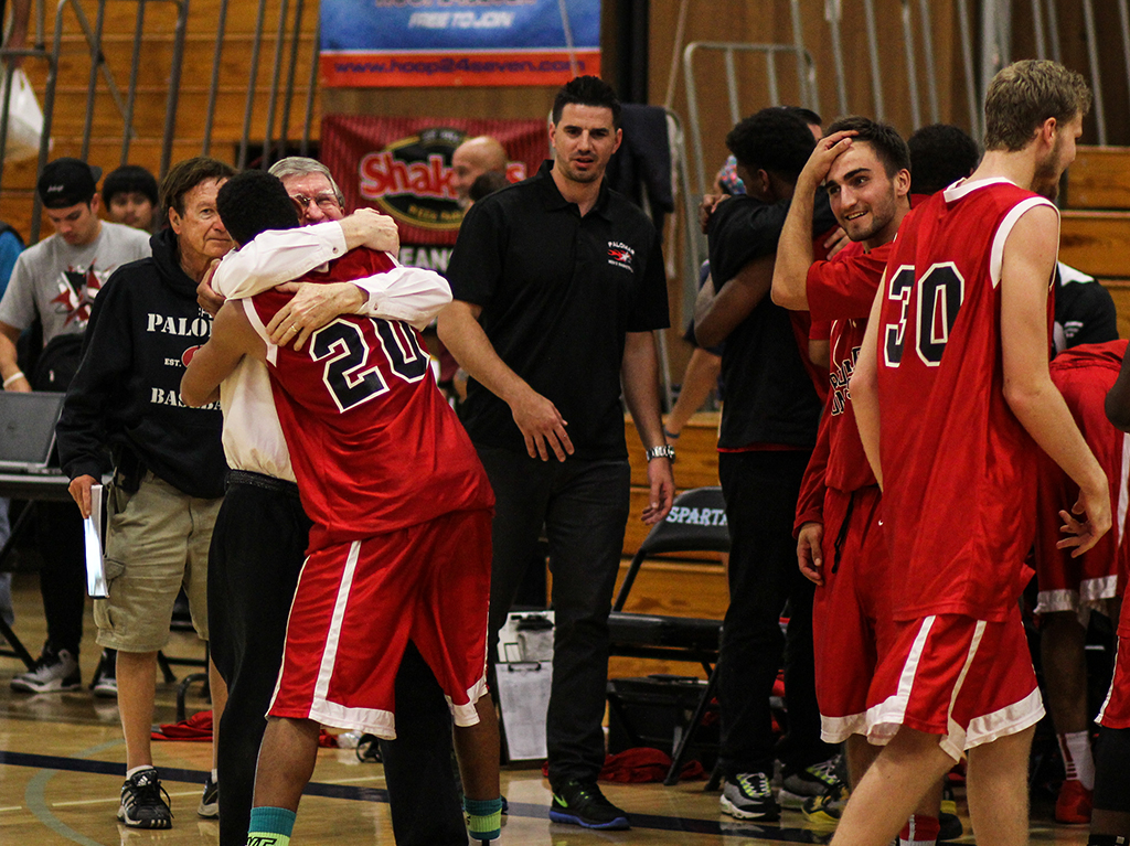 Palomar College Comets' head coach John O'Neill embraces Deven Riley #20 after their win over the Mira Costa Spartans. Riley scored 26 points for the Comets. The final score was 67-62 after a period of overtime, making the Palomar men's basketball team champions of the PCAC on Feb. 20, 2015. (Dirk Callum/The Telescope)