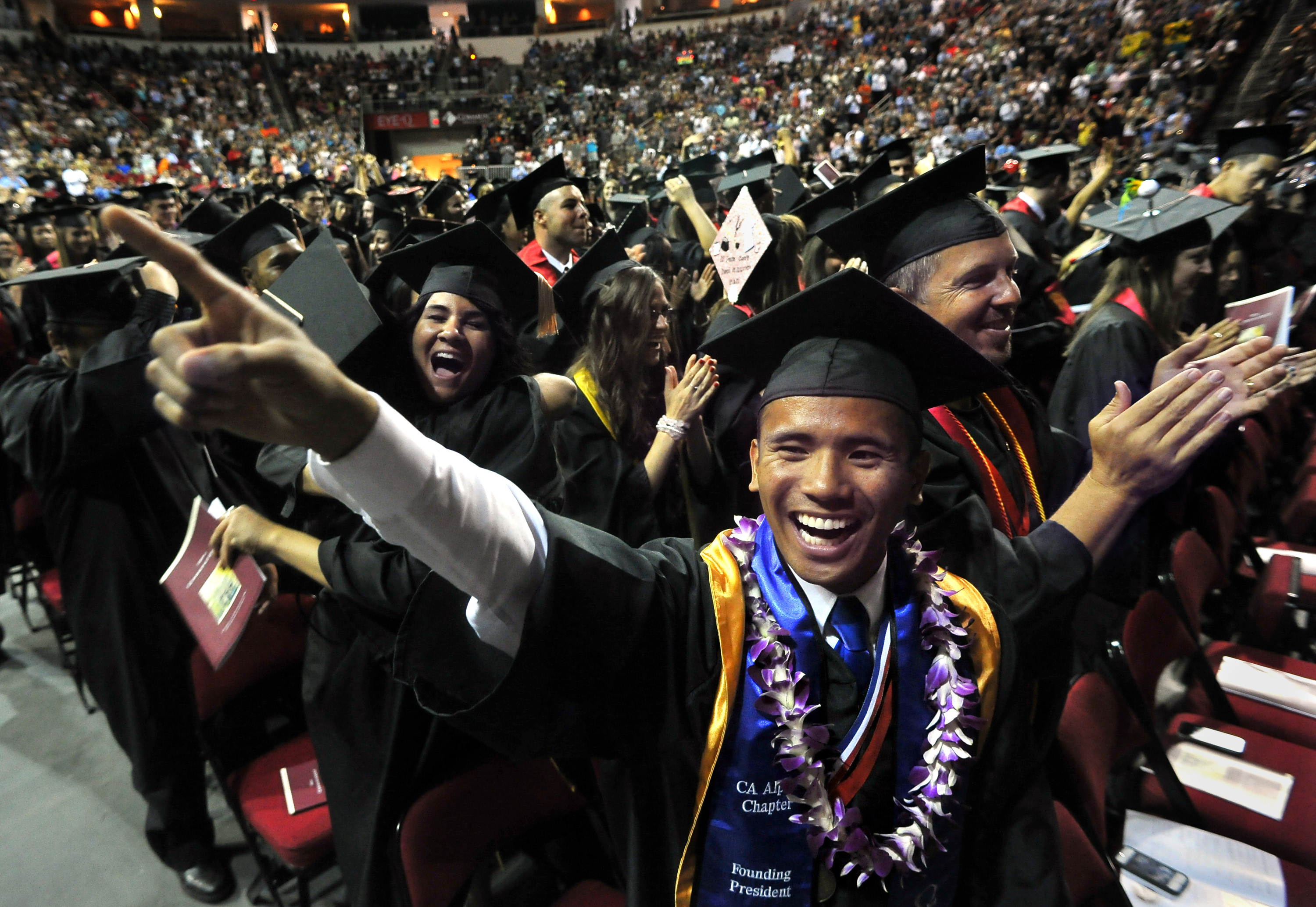 Junrel Sumagang gestures to family as he celebrates receiving his Bachelor of Science degree in nursing at the conclusion of Fresno State University's 101st Commencement at the Save Mart Center in Fresno, California, on Saturday, May 19, 2012. (John Walker/Fresno Bee/MCT)