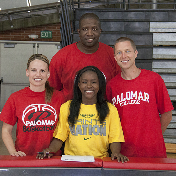 Palomar's Lee Lee Tomlinson (center) with Head Coach Leigh Marshall, Assistant Coach Damian Cephas, and Assistant Coach Chris Kroesch on April 8, 2015 in The Dome prior to signing her letter of intent to Presentation College. Tomlinson will be attending Presentation, located in Aberdeen South Dakota, on a basketball scholarship. (Stephen Davis/The Telescope)