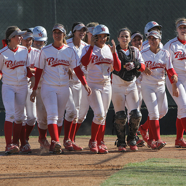 The Palomar Women's Softball team wait at home base for teammate Brooke Huddleson (4) to congratulate her on the home run hit that resulted in 3 points for Palomar against Mt. San Antonio, April 4, 2015 Palomar had previously beaten Santiago Canyon College during their first double-header game 5-2, and came out on top of Mt. San Antonio 4-1. (Dirk Callum/The Telescope)