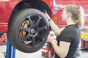 Kadi Donnelly, automotive technology student, checks for proper tire tread depth. Stephen Davis/The Telescope