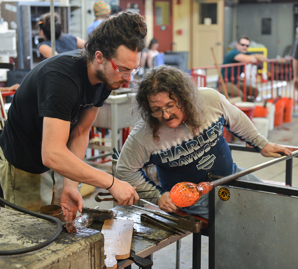 Logan Groupe’ (l) assists Mark Lessard (r) during the shaping of a hand blown piece for the T-Th, 8 a.m. class at Palomar on Tuesday Sept. 15, 2015. Groupe’ uses a caliper to aid Lessard in sculpting his work. (Brandy Sebastian/The Telescope)