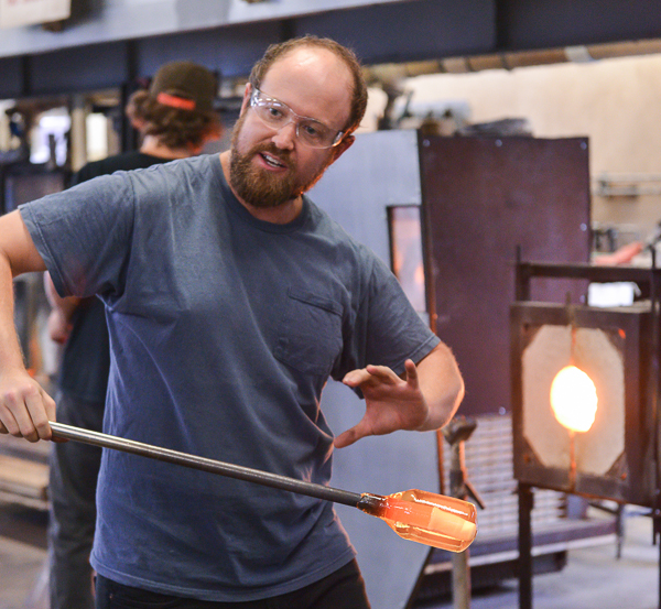 Michael Hernandez instructs a demonstration for his Glass-Blowing 3 students in the campus studio on Tuesday Sept. 15. The purpose of this demo was to show students how to create cane for use in decorating their work. Cane is a cross section of glass made by pulling and stretching molten glass from both ends. Brandy Sebastian/The Telescope