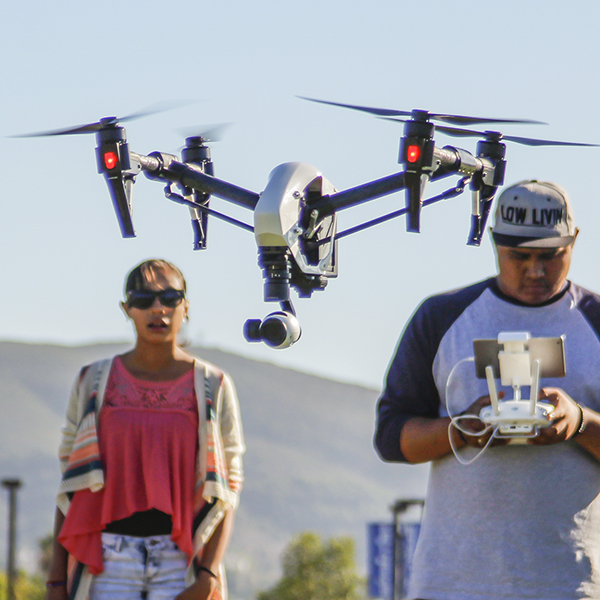 Victor Ramirez (C)is midflight of his U.A.V DJI-S900 along side of Professor Mark Bealo (R) and Michelle Ramierz ( L). Victor Ramirez is one of 22 students in the Digital Imaging with Drones course at the San Marcos campus. SEP 2015 Hanadi Cackler/ The Telescope