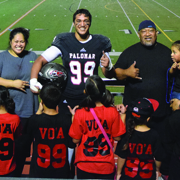Arnold Vo’a and his family pose to show their custom shirts after the football game on Sept. 19 at Escondido High School’s Wilson Stadium. (Michelle Wilkinson/The Telescope)