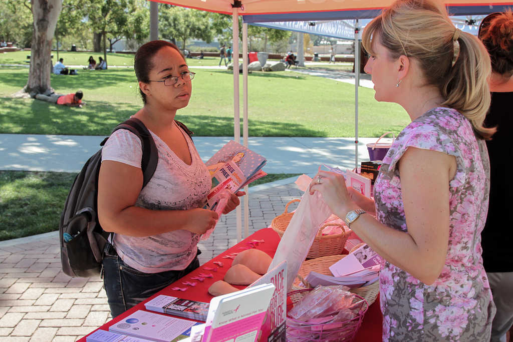 In observance of National Breast Cancer Awareness Month Lenka Schalkle (far right), of Palomar College Studen Health Services provides a variety of matierials to Veronica Garcia at a display adjacent to the student union. Oct. 13, 2015. (Lou Roubitchek/The Telescope)
