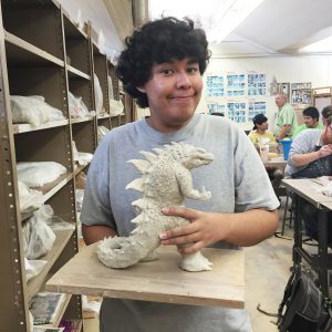 Palomar student Freddy Salgado holds his Godzilla inspired ceramic creation. Cristina Angel/The Telescope