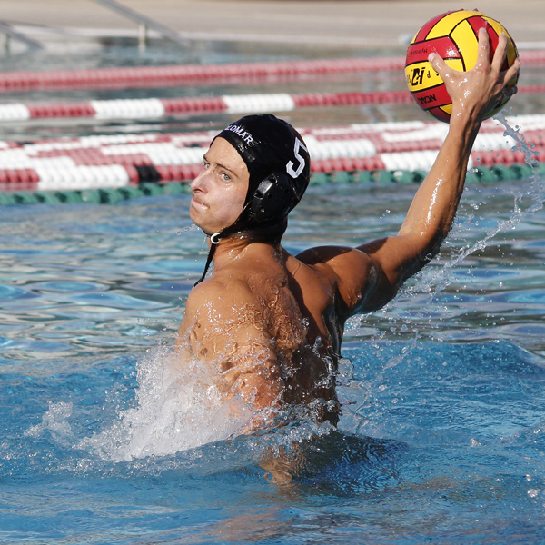 A male Palomar water polo player throws a ball with his right hand.
