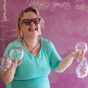 Palomar Student Artist Kris Bandanas proudly poses with some of the blown glass artwork that she has created in her glass blowing class on October 24, 2016. Joe Dusel / The Telescope.