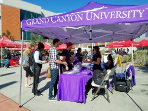 Michelle Muniz, Grand Canyon University transfer specialist, helps Trent Chavez Matzel, 1st year Business Management, and Jon Miller, 2nd semsester Business major, as she manages the booth at the annual Palomar College Fair. GCU was one of many schools that attended this event. Zachary Maxwell/The Telescope