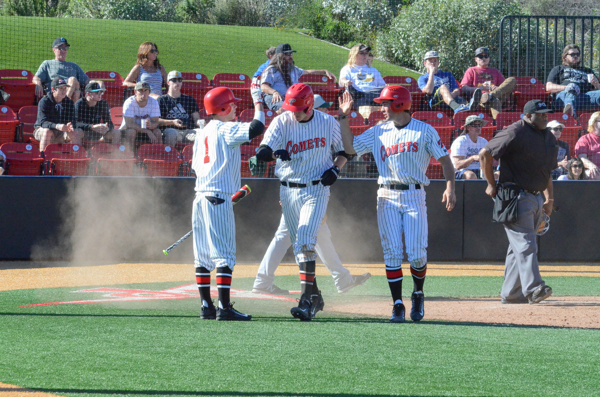 Gabe Willes (1) high fives his teammates after they scored back to back runs during the Jan. 28 game vs. Golden West. Palomar won 8-7.Tracy Grassel/The Telescope
