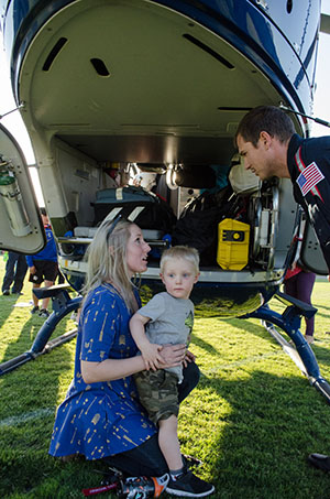 Mercy Air Flight Physician, Jesse Guittard (right), shows Jessica Horn and her son, Jackson, the area where patients are kept during medical airlifts as part of the First Annual Public Safety Community Outreach event held at Palomar College on April 5, 2017. Law enforcement agencies throughout the county also participated in the activities at the Palomar College Student Union Quad. Kathleen Coogan/The Telescope