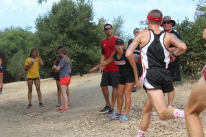 Coach Sonia Rodriguez urges on one of her runners at the Palomar Invitational at Guajome Park in Oceanside on Sept. 8. Justin Gonzalez/The Telescope.