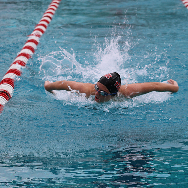 Swimmer Jordan Heimback swims in the breaststroke style in a pool.