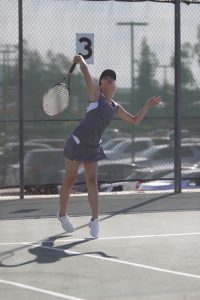 Comets tennis player, Erin Sugimoto, serves the ball, Feb. 15. Taylor Hardey / The Telescope