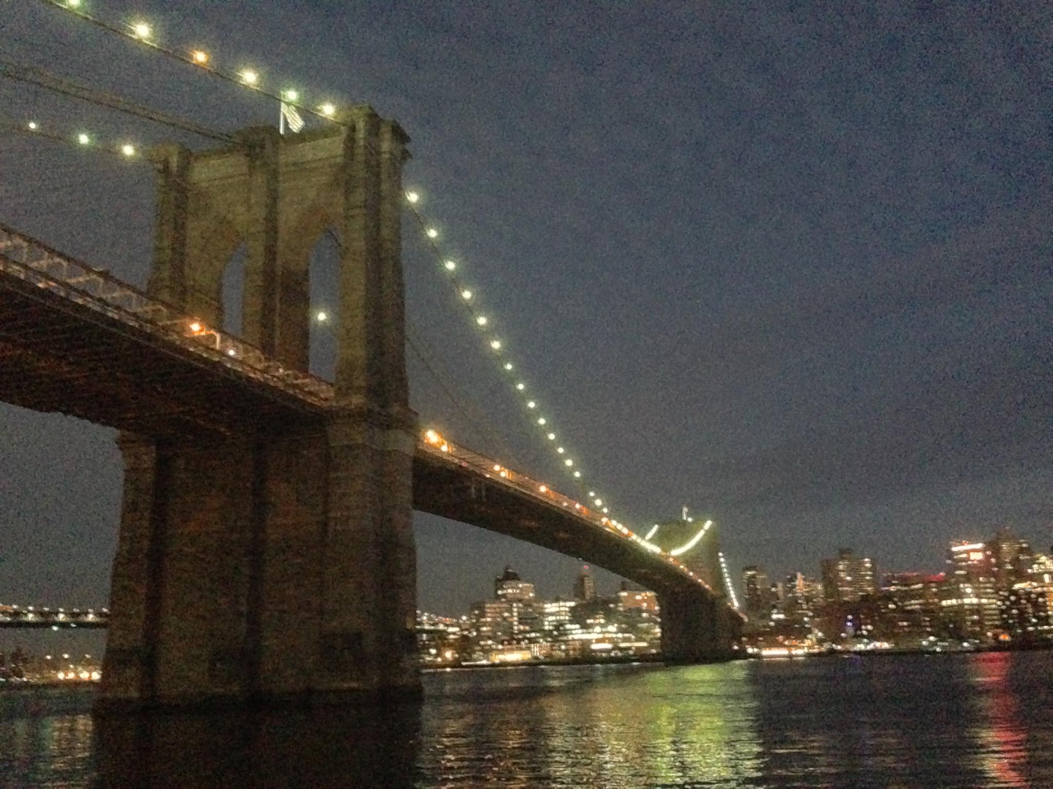Brooklyn Bridge at dusk from the waterfront.