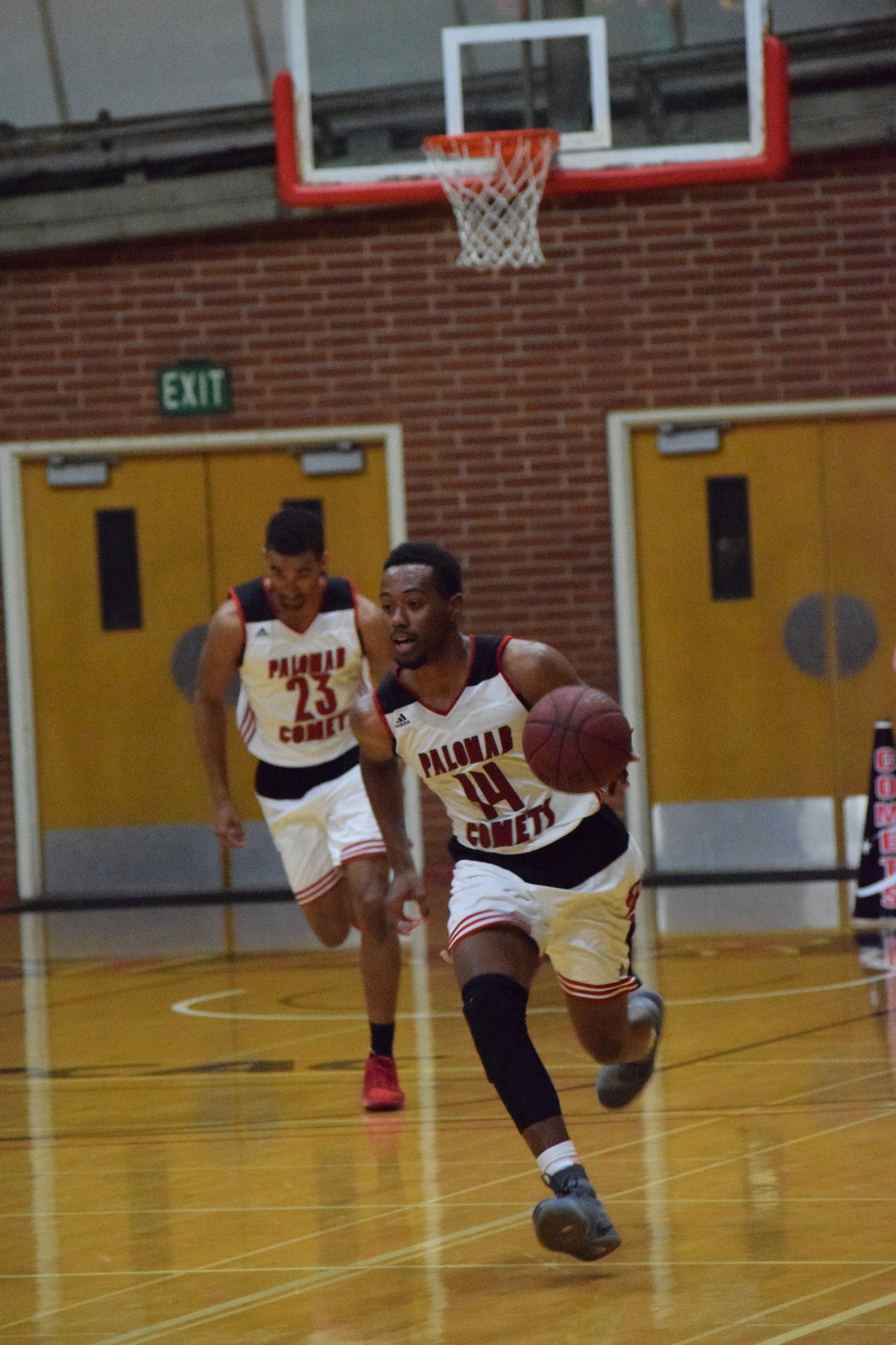 Palomar Comet basketball player number 14, LaVale Coleman, running the ball down to the opposite end of the court to score a point with number 23, Michael Chatman, hard on his heels. Feb 2. Emily Whetstone/The Telescope