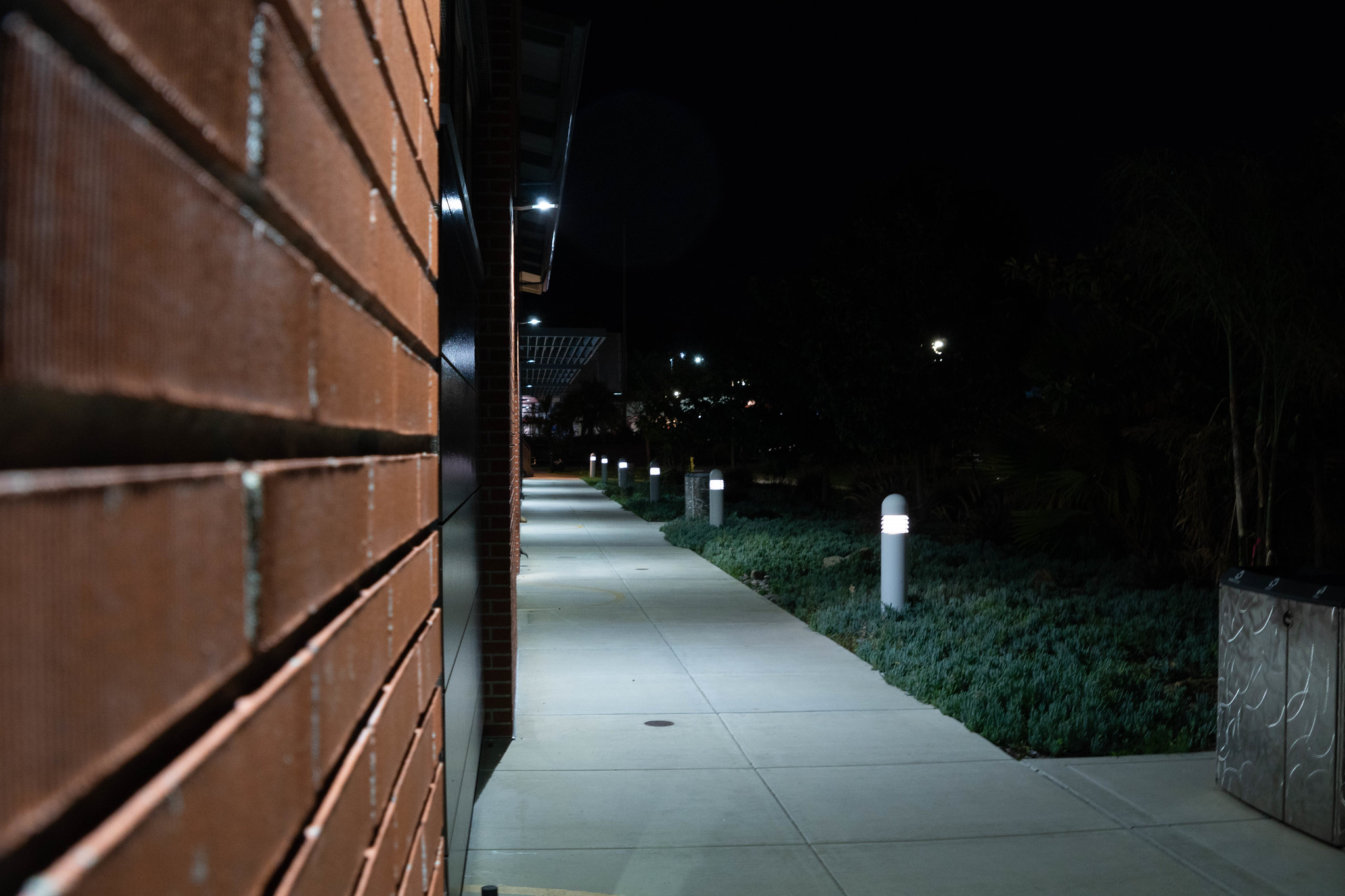 The walkway next to the H building being brightly lit by lights on and near the building. April 10, 2019. Blake Northington/ The Telescope