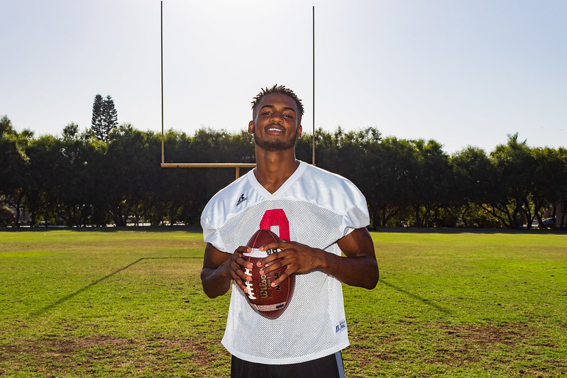 Palomar football player Kyran Griffin stands and holds a football with both hands