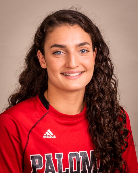 Portrait of Palomar basketball player Sara Ahmadpour who is wearing a red shirt with the word "Palomar" in the front. She has long wavy brown hair.