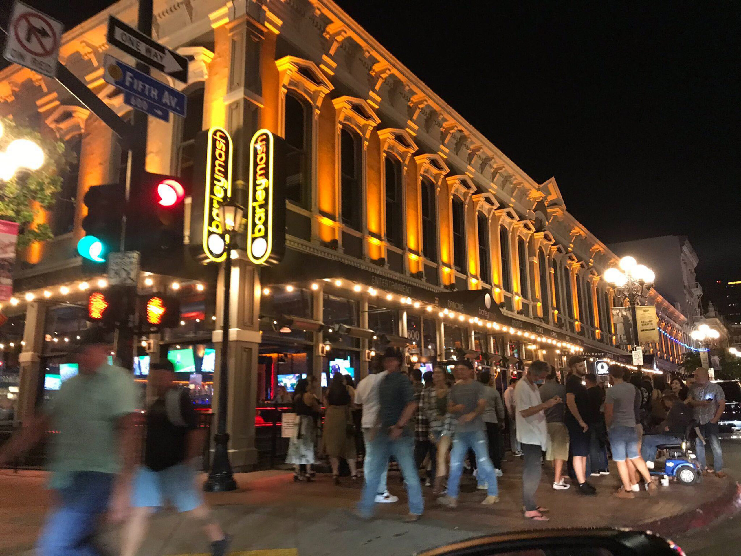 People walk around Gaslamp Quarter in at Fifth Ave. at night.