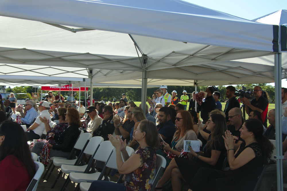 A crowd sits beneath a white tent outdoors for a groundbreaking ceremony for Palomar College.