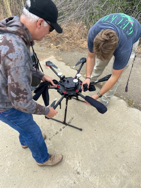 student and professor handle a large drone